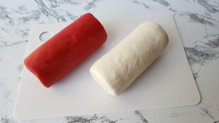 Red and white cookie dough shaped into logs.