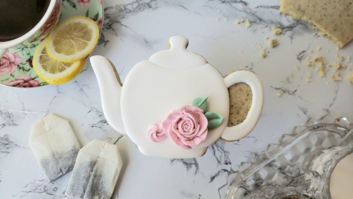 An earl grey shortbread sugar cookie decorated to look like a white tea pot.