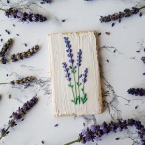 A lavender shortbread sugar cookie decorated with royal icing lavender flowers.