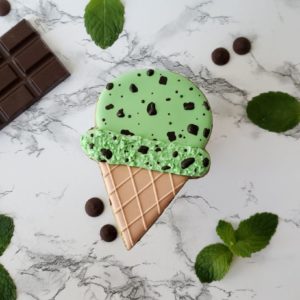 A mint chip shortbread sugar cookie decorated like a mint chip ice cream cone.