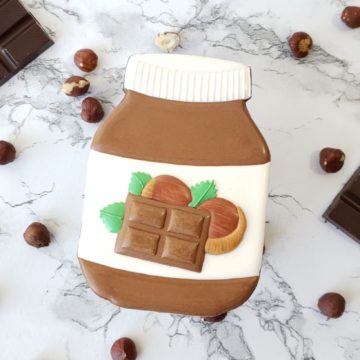 A chocolate hazelnut shortbread sugar cookie decorated to look like a jar of chocolate hazelnut spread.
