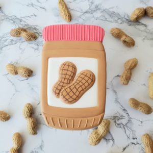 A peanut butter shortbread sugar cookie decorated to look like a jar of peanut butter.