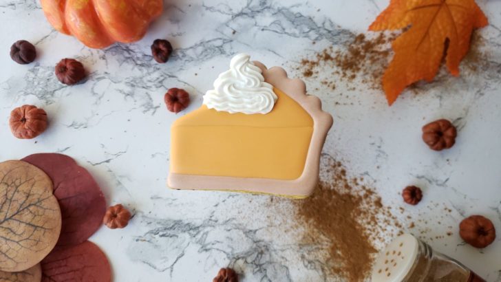 A single pumpkin pie shortbread sugar cookie decorated to look like a slice of pumpkin pie. 