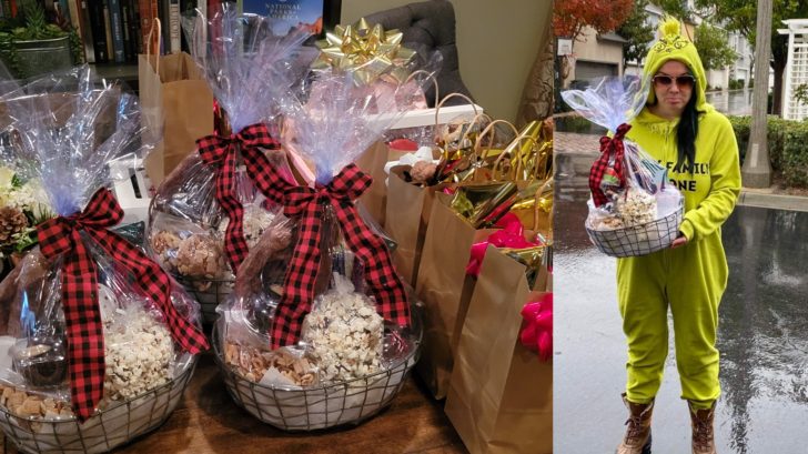 A table filled with Christmas gift baskets, next to a picture of a woman dressed like The Grinch holding a gift basket. 