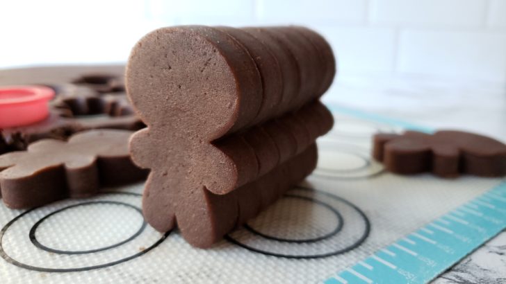 Gingerbread men cookie dough cutouts stacked together. 