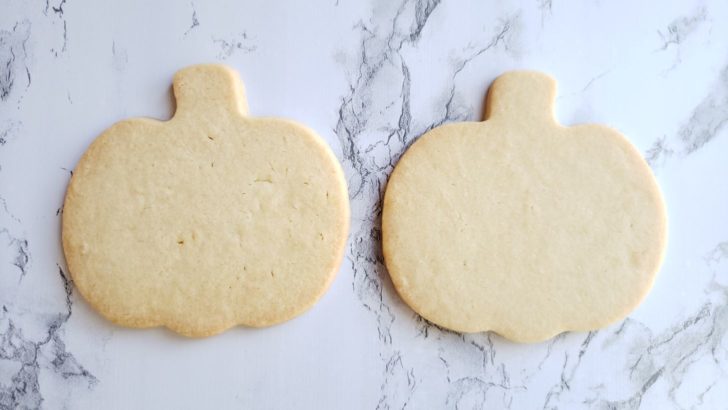 Two pumpkin shaped blank cookies.