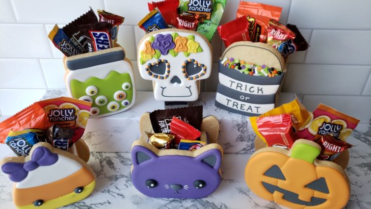 Halloween treat boxes made from decorated cookies and filled with Halloween candy.