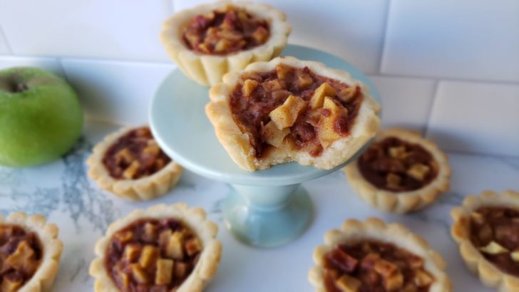 Apple pie tartlets sitting on a mini dessert stand.