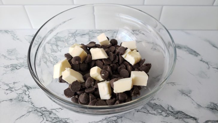a glass bowl with chocolate chips and butter.