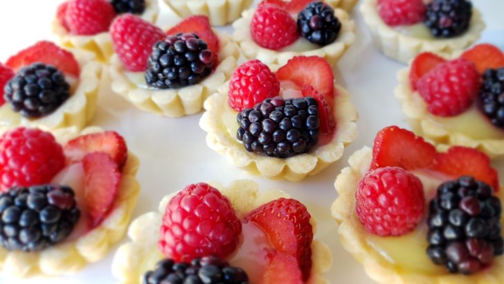 Close up of Fruit tarts with lemon curd, blackberries, raspberries, and strawberries.