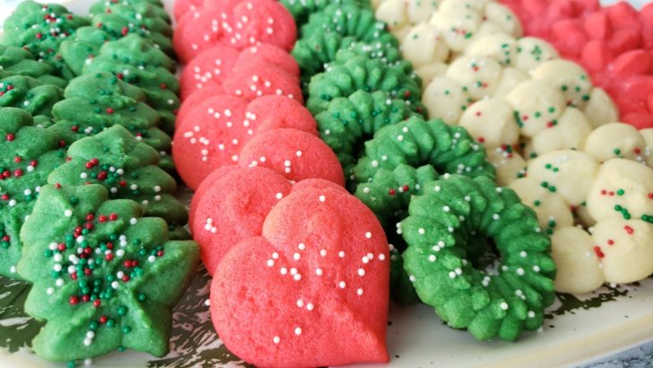 Close up view of green, red, and white Christmas spritz cookies on a platter.